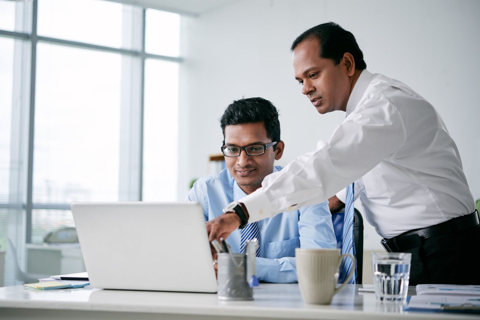 Two team members reviewing a proposal on a laptop