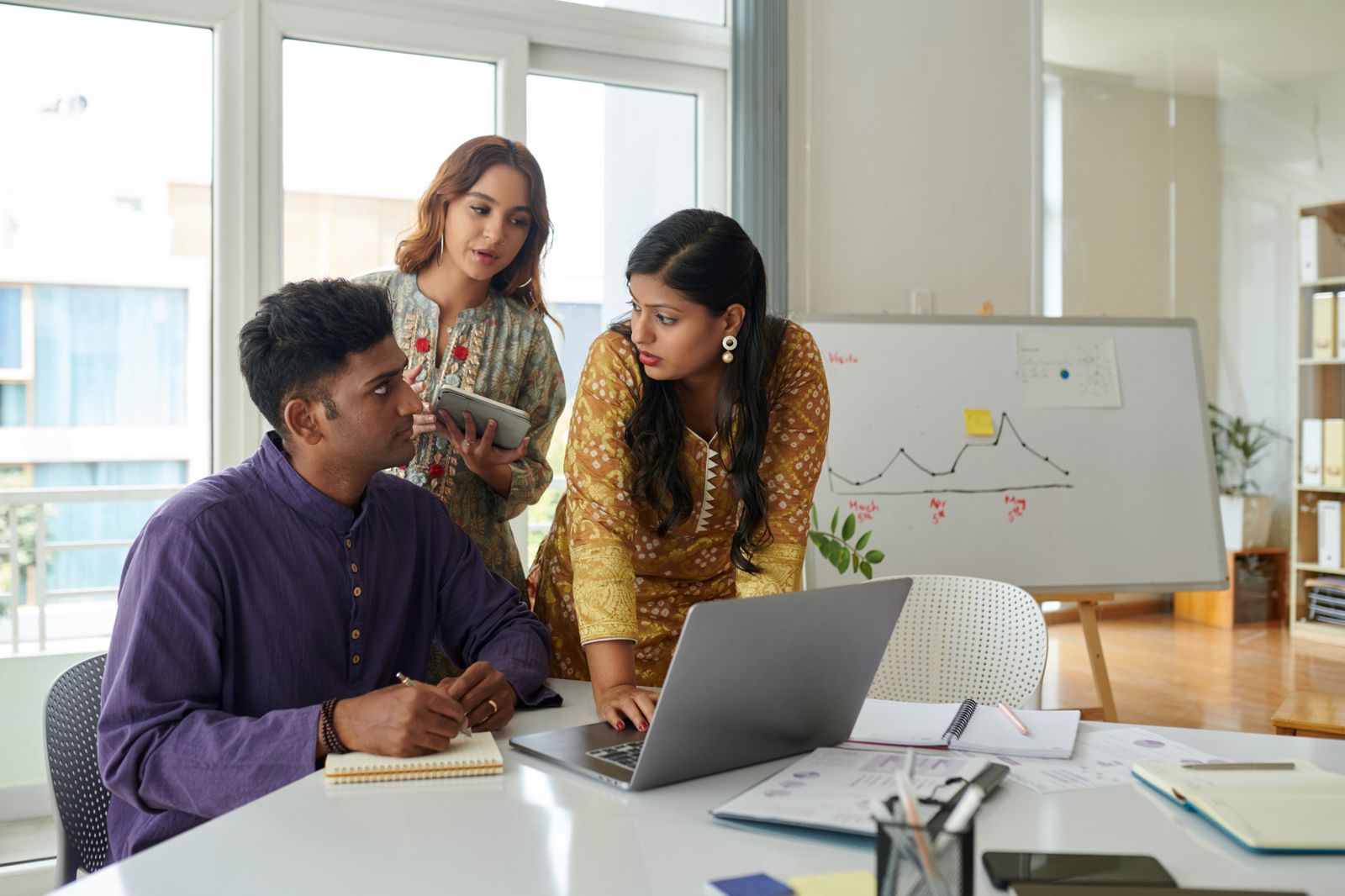 SEO team reviewing organic traffic growth against a chart on the whiteboard